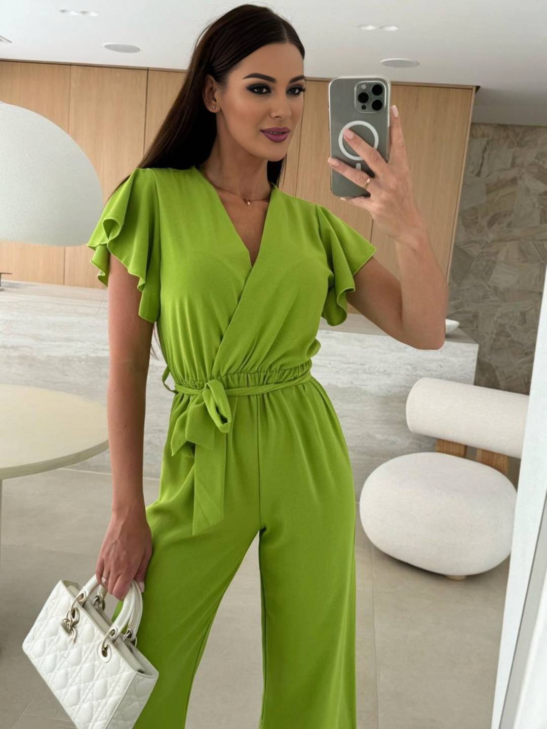 Kombinezon damski Rochelle – elegancki jednolity kombinezon z dekoltem w serek, paskiem i szerokimi nogawkami z falbanami